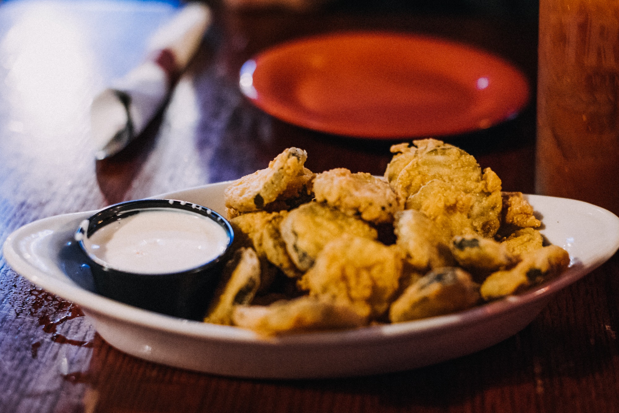 Fried pickles and ranch dressing and a plate